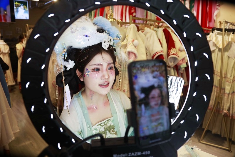 在河南省洛陽市一家漢服店里,一位頭戴龍形頭飾的主播在推廣漢服文化。人民網記者 慎志遠攝